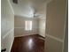 Cozy bedroom with hardwood floors, neutral walls, ceiling fan, and window with vertical blinds at 707 Great Barford St, Auburndale, FL 33823