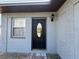 Exterior view of front door, light fixture and painted brick at 707 Great Barford St, Auburndale, FL 33823