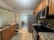 Updated kitchen features stainless steel appliances, granite countertops, mosaic backsplash, and wood cabinetry at 707 Great Barford St, Auburndale, FL 33823