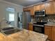 Updated kitchen features stainless steel appliances, granite countertops, mosaic backsplash, and wood cabinetry at 707 Great Barford St, Auburndale, FL 33823