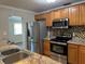 Updated kitchen features stainless steel appliances, granite countertops, mosaic backsplash, and wood cabinetry at 707 Great Barford St, Auburndale, FL 33823