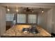 Spacious kitchen island with a double sink, granite countertops, track lighting, and two windows at 707 Great Barford St, Auburndale, FL 33823