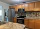 Updated kitchen features stainless steel appliances, granite countertops, mosaic backsplash, and wood cabinetry at 707 Great Barford St, Auburndale, FL 33823