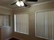 Bright room featuring hardwood floors, neutral walls, and large windows with vertical blinds and ceiling fan at 707 Great Barford St, Auburndale, FL 33823