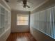 Bright room featuring hardwood floors, textured walls, and large windows with vertical blinds and built-in shelves at 707 Great Barford St, Auburndale, FL 33823