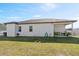 Spacious backyard featuring healthy green grass, a covered patio, and a white fence enhancing privacy at 747 Fraser Ct, Kissimmee, FL 34759