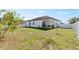 Spacious backyard featuring healthy green grass, a covered patio, and a white fence enhancing privacy at 747 Fraser Ct, Kissimmee, FL 34759