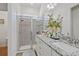 Bathroom featuring dual sinks with granite countertops and glass enclosed shower at 747 Fraser Ct, Kissimmee, FL 34759