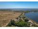 Picturesque aerial of lakeside property surrounded by open fields and gorgeous waterfront access at 819 Seminole Rd, Babson Park, FL 33827