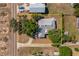 Aerial view of the house showcasing its roof, landscaping, and proximity to a neighboring road and houses at 819 Seminole Rd, Babson Park, FL 33827
