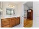 Bathroom vanity featuring a wooden cabinet, white countertop, and a decorative mirror with views of the shower at 819 Seminole Rd, Babson Park, FL 33827