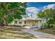 Inviting two-story house with a concrete driveway, lush trees and well manicured grounds at 819 Seminole Rd, Babson Park, FL 33827