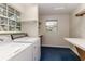 Functional laundry room with washer, dryer, shelving, and ample workspace at 819 Seminole Rd, Babson Park, FL 33827