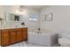 Well-lit main bathroom featuring a soaking tub, vanity, and modern fixtures at 819 Seminole Rd, Babson Park, FL 33827