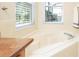 Close up on tiled bath tub with a large window for natural lighting at 908 Orista Dr, Davenport, FL 33897