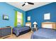 Blue bedroom with two twin beds, side tables, and a wall-mounted TV at 908 Orista Dr, Davenport, FL 33897