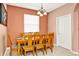 Inviting dining area with a wooden table and six chairs, illuminated by a charming chandelier at 908 Orista Dr, Davenport, FL 33897