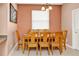 Cozy dining room with a wooden table set for six, natural light, and neutral decor at 908 Orista Dr, Davenport, FL 33897