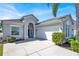 Stylish single-story home boasts a two-car garage, well-maintained landscaping, and a stucco exterior with a welcoming entrance at 908 Orista Dr, Davenport, FL 33897