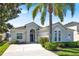 Charming single-story home featuring a stucco exterior, a two-car garage, manicured landscaping, and a welcoming arched entryway at 908 Orista Dr, Davenport, FL 33897