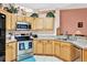 Well-lit kitchen features stainless steel appliances, light wood cabinets, and tile flooring at 908 Orista Dr, Davenport, FL 33897