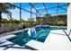 Pool with spa surrounded by landscaping and a screen at 908 Orista Dr, Davenport, FL 33897