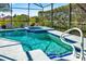 Inviting screened-in pool and spa with lush tropical landscaping at 908 Orista Dr, Davenport, FL 33897