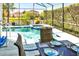 Relaxing screened-in pool and spa area with dining and backyard views at 908 Orista Dr, Davenport, FL 33897