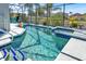 A screened-in pool with a spa and lush landscaping at 908 Orista Dr, Davenport, FL 33897