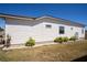 The exterior side of the home with a well maintained lawn and a landscaped area at 1055 Canary S Cir, Lakeland, FL 33809