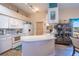 Well-lit kitchen boasts white cabinets, a spacious counter, modern appliances, and beach themed decor at 1055 Canary S Cir, Lakeland, FL 33809