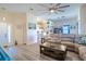Open-concept living room with neutral tones, a ceiling fan, and a view of the adjacent kitchen at 1055 Canary S Cir, Lakeland, FL 33809