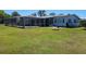 Exterior of home featuring large screened-in lanai and expansive green backyard at 121 Bonnie Dr, Auburndale, FL 33823