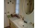 Charming bathroom with a sink, vanity and decorative mirror. Features a window and coastal decor at 121 Bonnie Dr, Auburndale, FL 33823