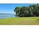 Beautiful lake view with lush green grass and mature shade trees at 121 Bonnie Dr, Auburndale, FL 33823