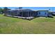 Enclosed pool with large screened enclosure, surrounded by green grass at 121 Bonnie Dr, Auburndale, FL 33823