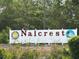 Nalcrest community sign with the US flag and a sunny logo at 1219 Club Cir, Lakeshore, FL 33854