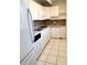 Compact kitchen featuring white cabinetry, tile floors, and modern appliances at 1219 Club Cir, Lakeshore, FL 33854
