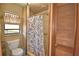 Cozy bathroom featuring a walk-in shower with a patterned curtain, toilet and storage closet at 122 Wgto Tower Rd, Lake Alfred, FL 33850