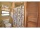 Cozy bathroom featuring a walk-in shower with a patterned curtain, toilet and storage closet at 122 Wgto Tower Rd, Lake Alfred, FL 33850