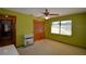 Bedroom featuring green walls, carpet flooring, fan, window and closet with wood doors at 122 Wgto Tower Rd, Lake Alfred, FL 33850
