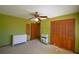 Bedroom featuring green walls, carpet flooring, fan, dresser and closet with wood doors at 122 Wgto Tower Rd, Lake Alfred, FL 33850