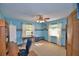 Bedroom featuring blue walls, carpet flooring, fan, two windows and light colored curtains at 122 Wgto Tower Rd, Lake Alfred, FL 33850