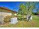 Backyard exterior of home featuring a generator, propane tanks and a wooded view at 122 Wgto Tower Rd, Lake Alfred, FL 33850