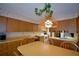 Eat-in kitchen features wood cabinets, vintage light fixture, and light countertops at 122 Wgto Tower Rd, Lake Alfred, FL 33850