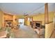Open-concept living room with stone fireplace, ceiling fan, carpet floors, and adjacent sunroom at 122 Wgto Tower Rd, Lake Alfred, FL 33850
