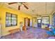 Enclosed sunroom featuring tile floors, ceiling fans, and large windows for natural light at 122 Wgto Tower Rd, Lake Alfred, FL 33850