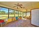 Bright sunroom with tiled floors, ceiling fans, and large windows offering scenic views of the outdoors at 122 Wgto Tower Rd, Lake Alfred, FL 33850