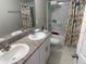 Bright bathroom featuring double sinks, granite countertop, and a shower-tub combo at 1393 Axel Cir, Winter Haven, FL 33880