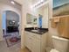 Bathroom featuring a granite countertop vanity, mirror, and decorative beach painting at 1402 Colonial Ct, Winter Haven, FL 33884